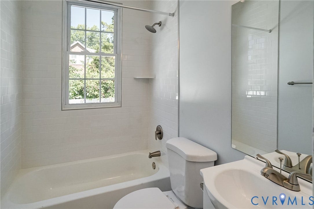 10024 Washington Road, Richmond, VA 23060 White subway tile surround, built-in bathtub, and window with exterior scenery