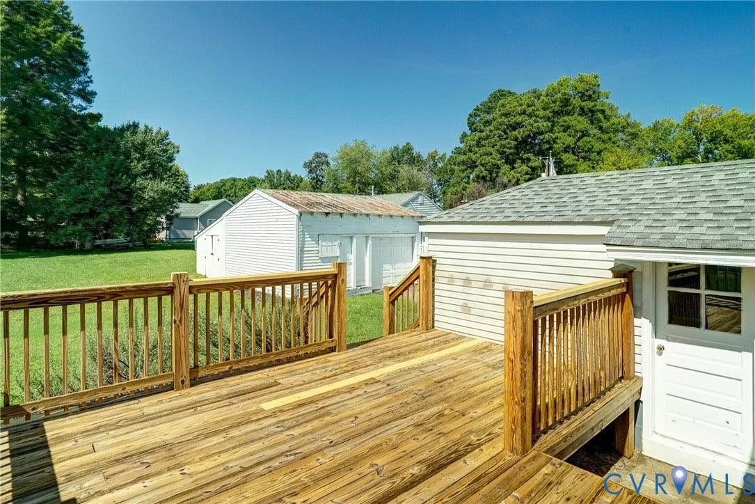 10024 Washington Road, Richmond, VA 23060 Expansive wooden deck with railing, offering access to a side entry door