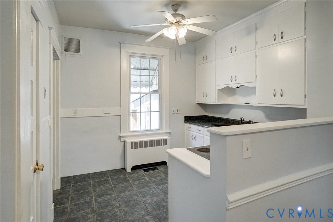 10024 Washington Road, Richmond, VA 23060 White cabinetry, dark stone-finish countertops, ceiling fan, and tiled flooring