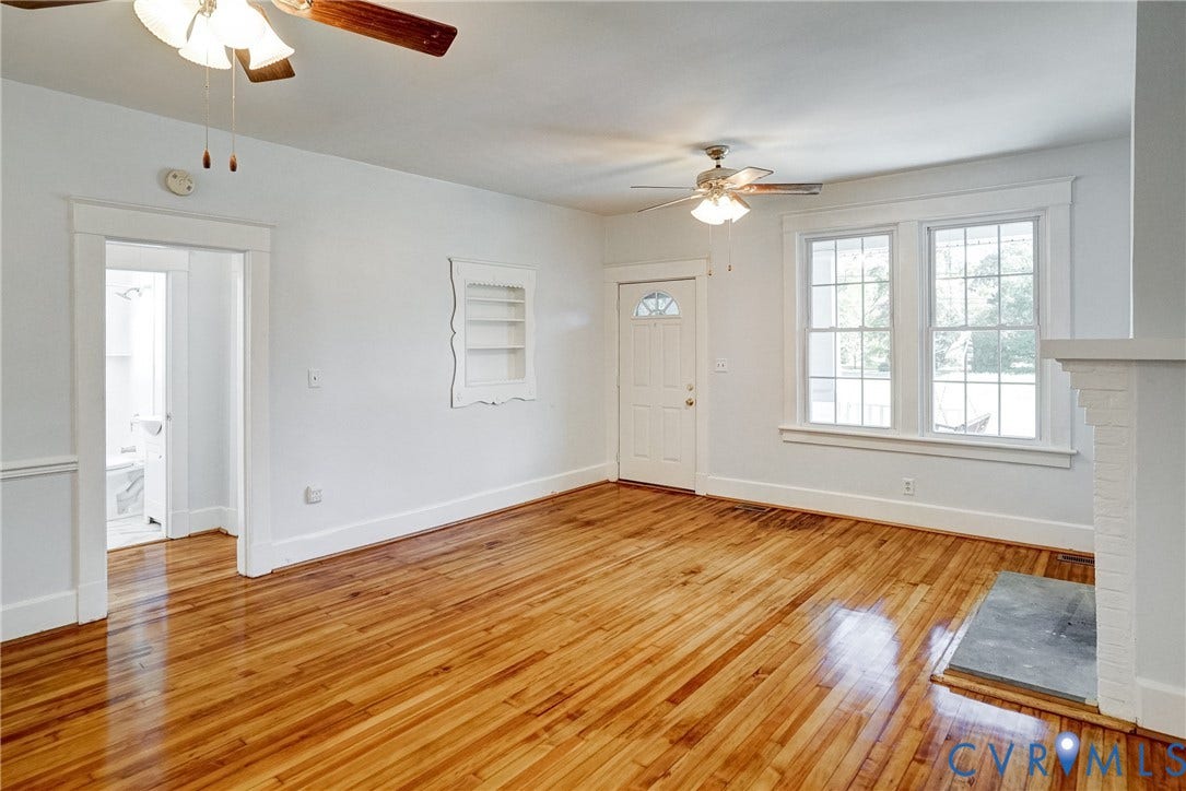 10024 Washington Road, Richmond, VA 23060 Hardwood flooring complemented by multiple windows, a decorative fireplace, ceiling fans, and a built-in wall shelf