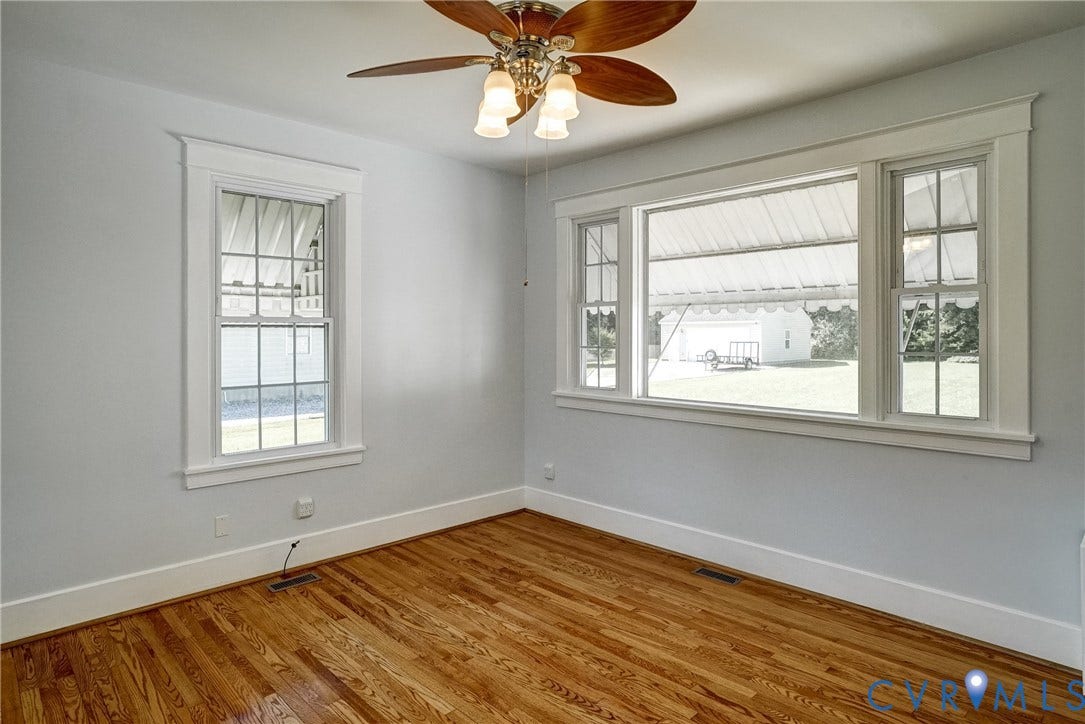 10024 Washington Road, Richmond, VA 23060 Hardwood flooring, painted walls, white trim, ceiling fan with light fixture, and multiple windows