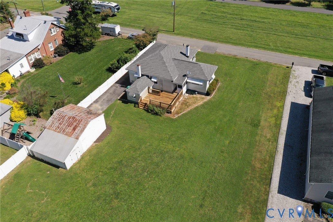 10024 Washington Road, Richmond, VA 23060 Expansive lawn with a white privacy fence, multi-level wood deck, and a detached outbuilding
