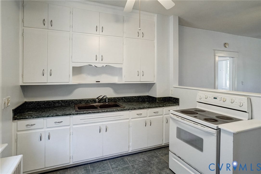 10024 Washington Road, Richmond, VA 23060 White cabinetry with ample storage, dark mottled countertop, double basin sink, and tile flooring