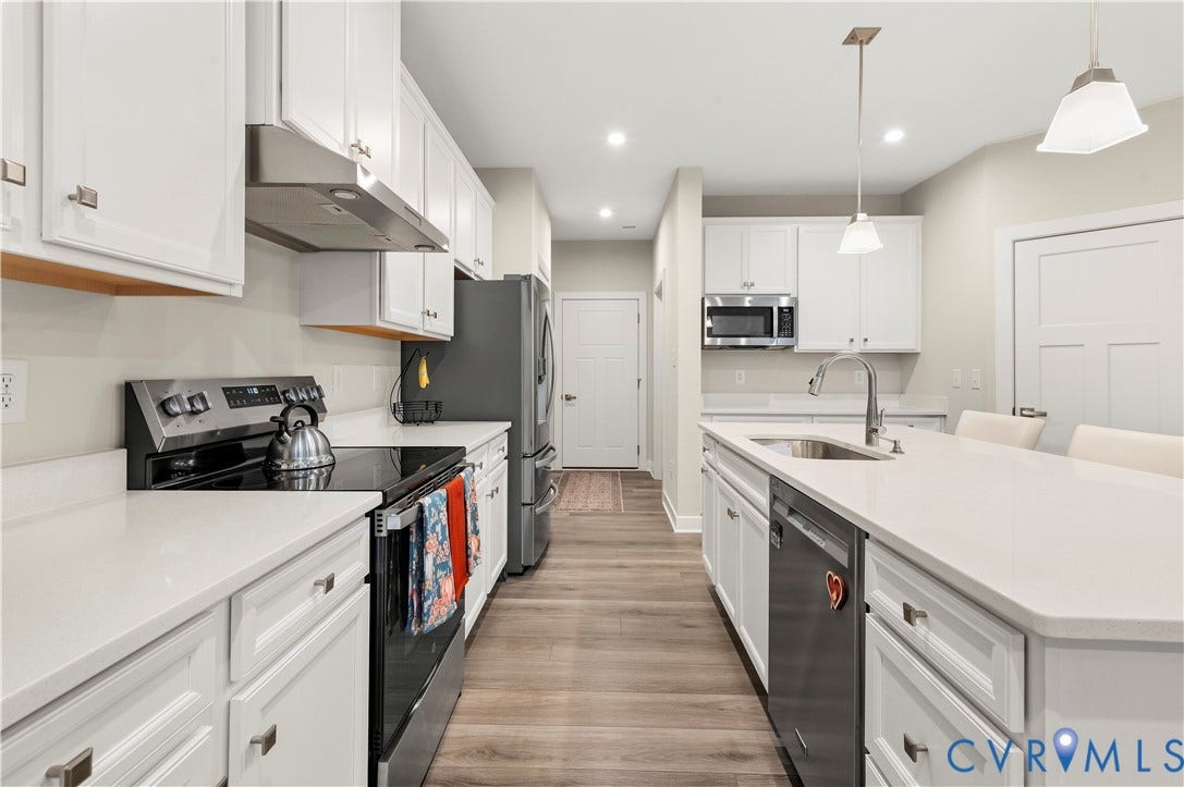 4837 Bacova Village Trail, Glen Allen, VA 23059 White shaker cabinetry, light-toned countertops, stainless steel appliances, wood-finish flooring, and recessed lighting