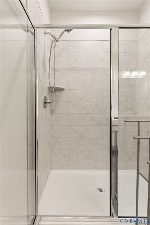 4837 Bacova Village Trail, Glen Allen, VA 23059 Glass-enclosed shower with a handheld showerhead, built-in shelf, tiled walls, and a white shower pan
