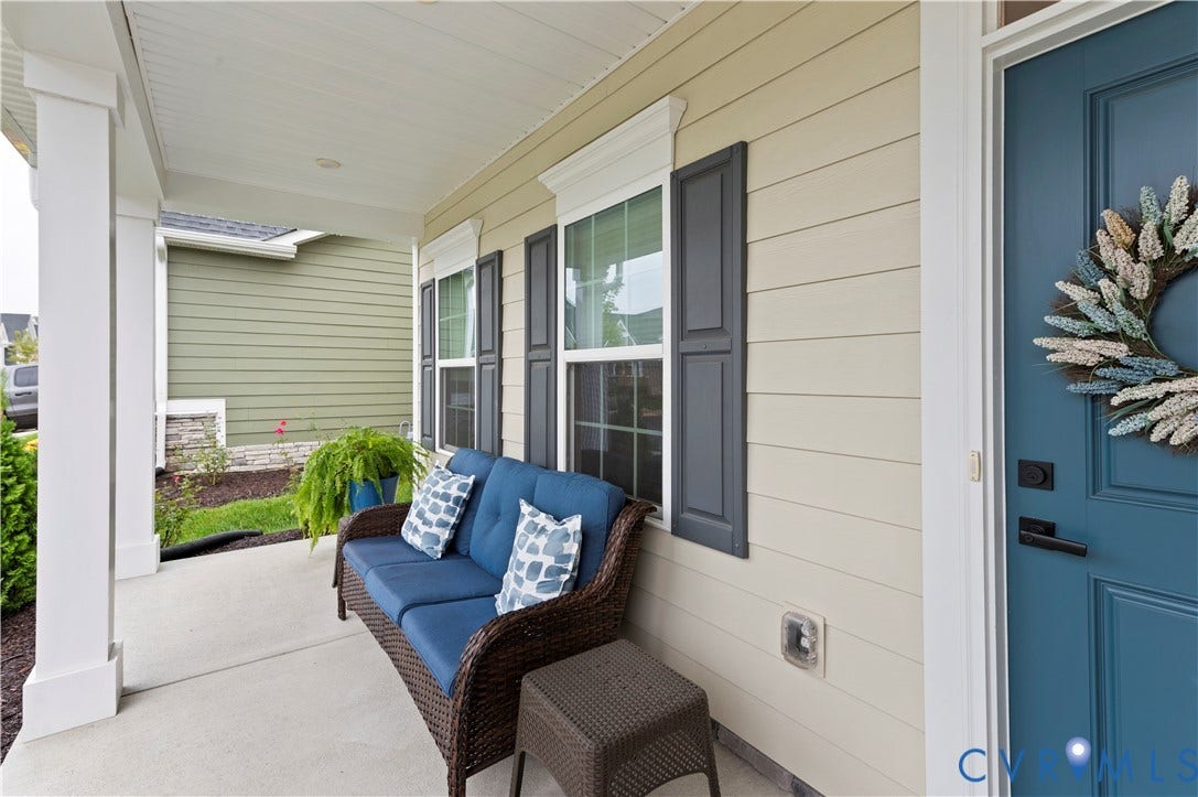 4837 Bacova Village Trail, Glen Allen, VA 23059 Covered front porch featuring white columns, a neutral-toned siding, dark shutters, and a blue entry door