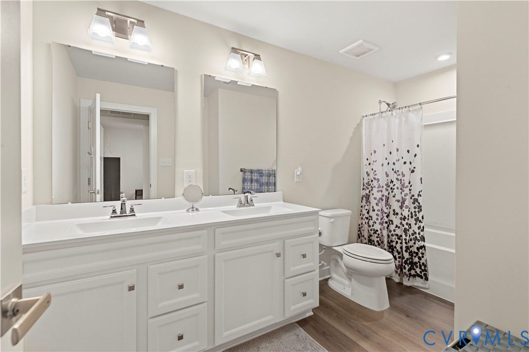 4837 Bacova Village Trail, Glen Allen, VA 23059 Double vanity with integrated sinks, brushed nickel fixtures, wood-finish flooring, recessed lighting, and a combination tub/shower