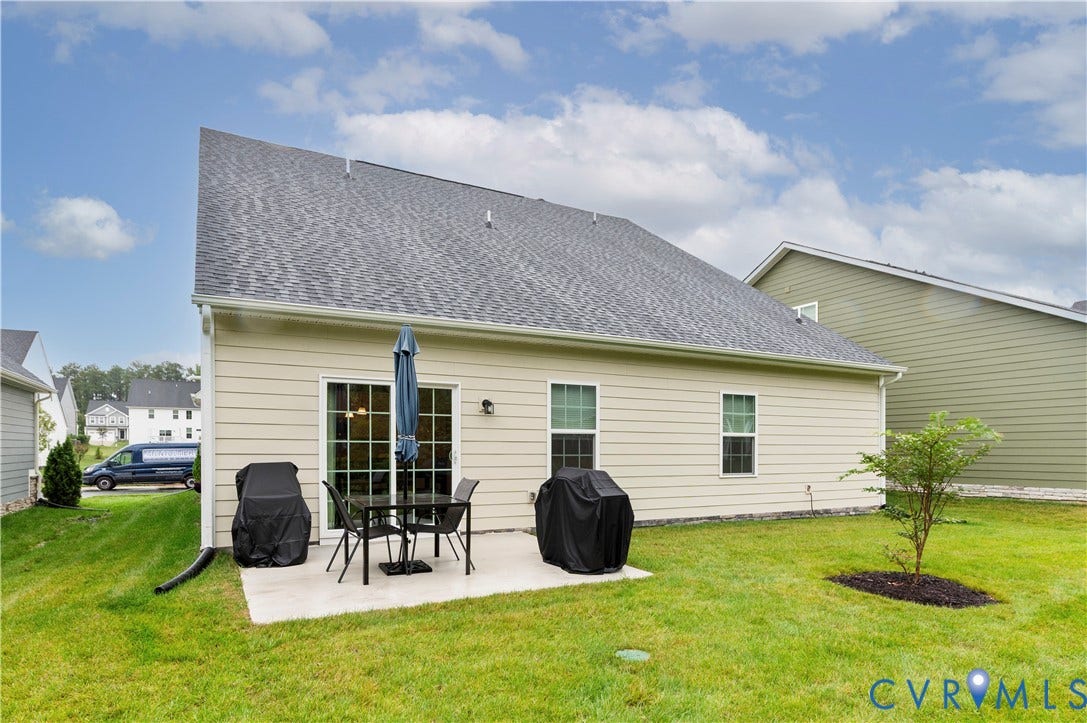 4837 Bacova Village Trail, Glen Allen, VA 23059 Manicured lawn with a concrete patio, sliding glass door, and twin windows