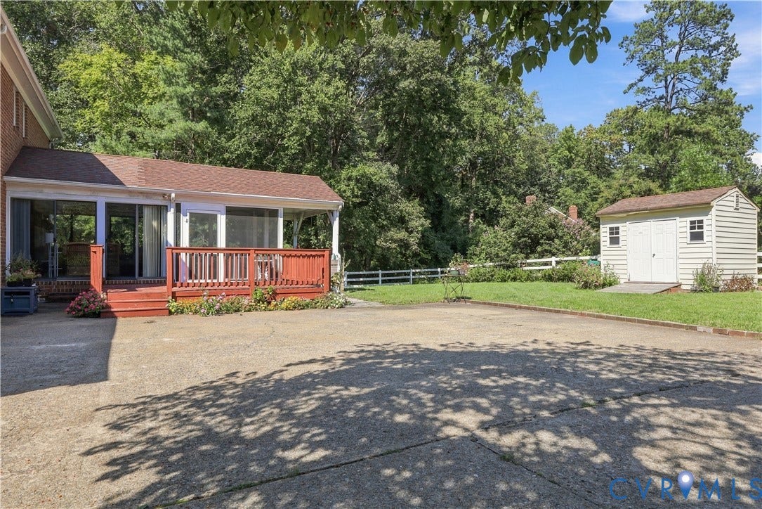 8307 Wallingford Lane, Chickahominy Bluffs, Henrico, VA 23227 Screened porch with an attached wooden deck, expansive paved patio, and a separate storage shed with double doors