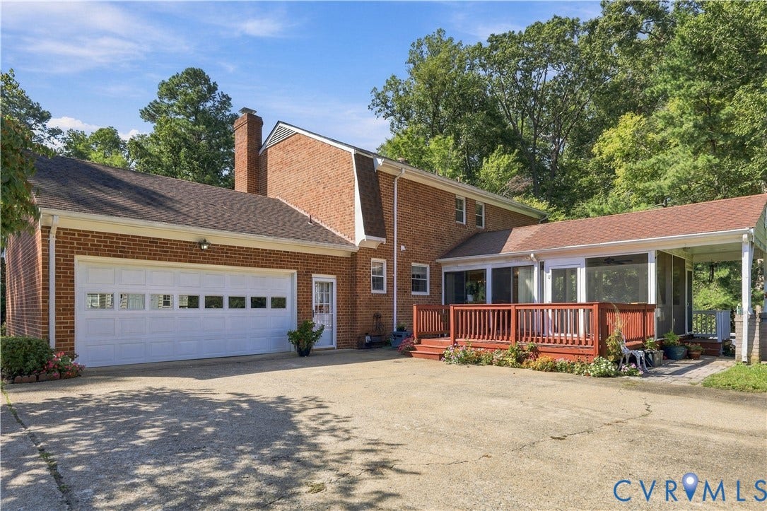 8307 Wallingford Lane, Chickahominy Bluffs, Henrico, VA 23227 Brick exterior featuring a two-car garage with panel windows, a red wood-finish deck, and a covered porch