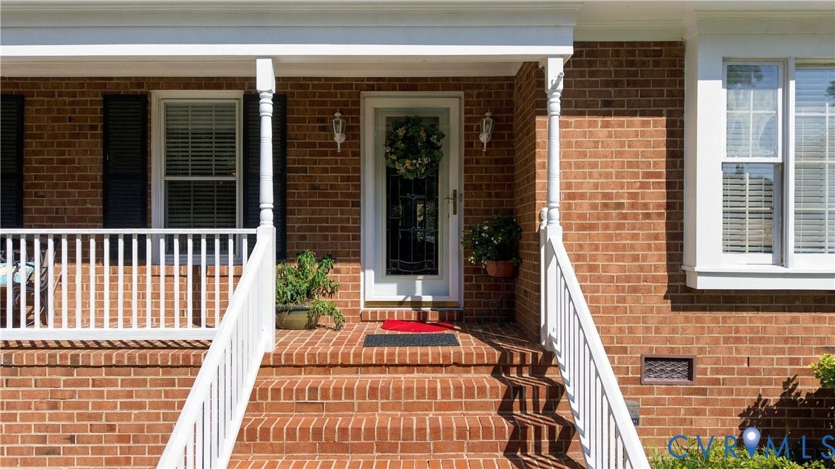 8307 Wallingford Lane, Chickahominy Bluffs, Henrico, VA 23227 Brick exterior featuring white window trim, white porch railing, and a white front door