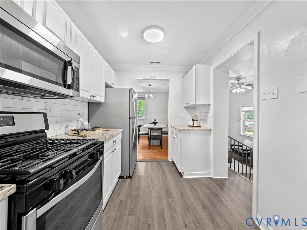 5112 Bethlehem Road, Libbie Mill Area, Richmond, VA 23230 Galley kitchen featuring wood-finish flooring, white cabinetry, a subway tile backsplash, light-toned countertops, and stainless steel appliances