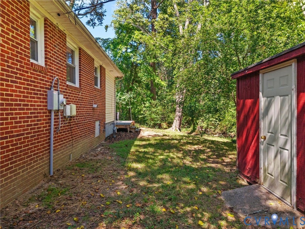 5112 Bethlehem Road, Libbie Mill Area, Richmond, VA 23230 Brick and siding exterior with a dedicated storage shed, partial grass lawn, and mature trees