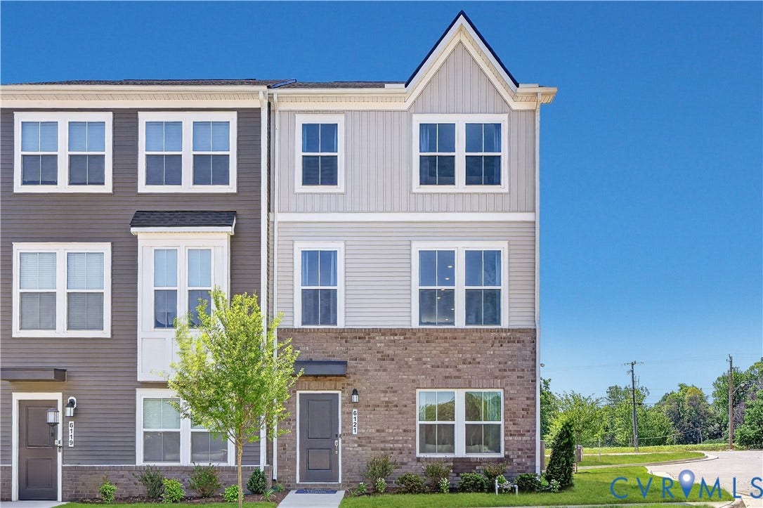 6126 Hull Street Road, Richmond, VA 23224 Three-story townhome with a brick and siding exterior, multiple window styles, and an inviting front entry