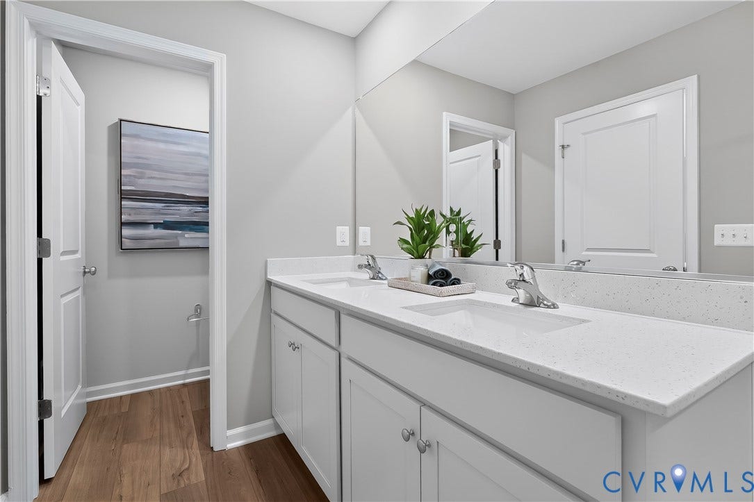 6126 Hull Street Road, Richmond, VA 23224 Dual vanity with integrated sinks, light-toned countertop, and wood-finish flooring