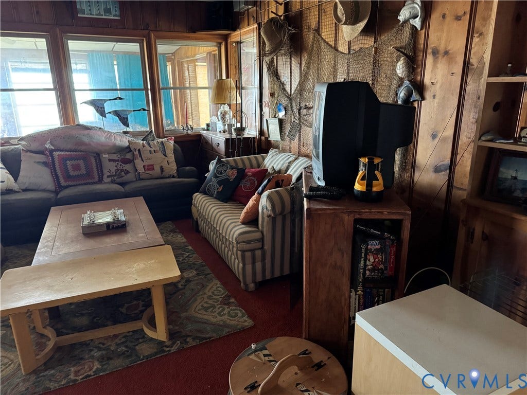 36 Beach Road, Reedville, VA 22539 Living space featuring wood-paneled walls, large windows, and built-in shelving