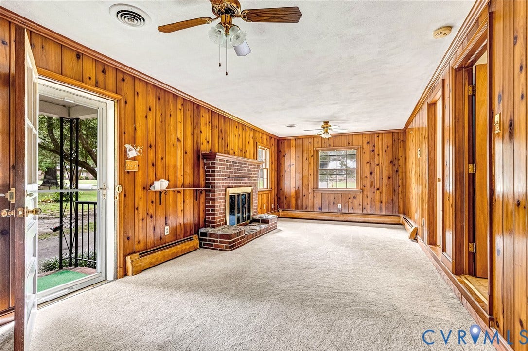 5215 Sprucewood Avenue, North Chesterfield, VA 23234 Wood paneling throughout, brick fireplace with hearth, and wall-mounted baseboard heating