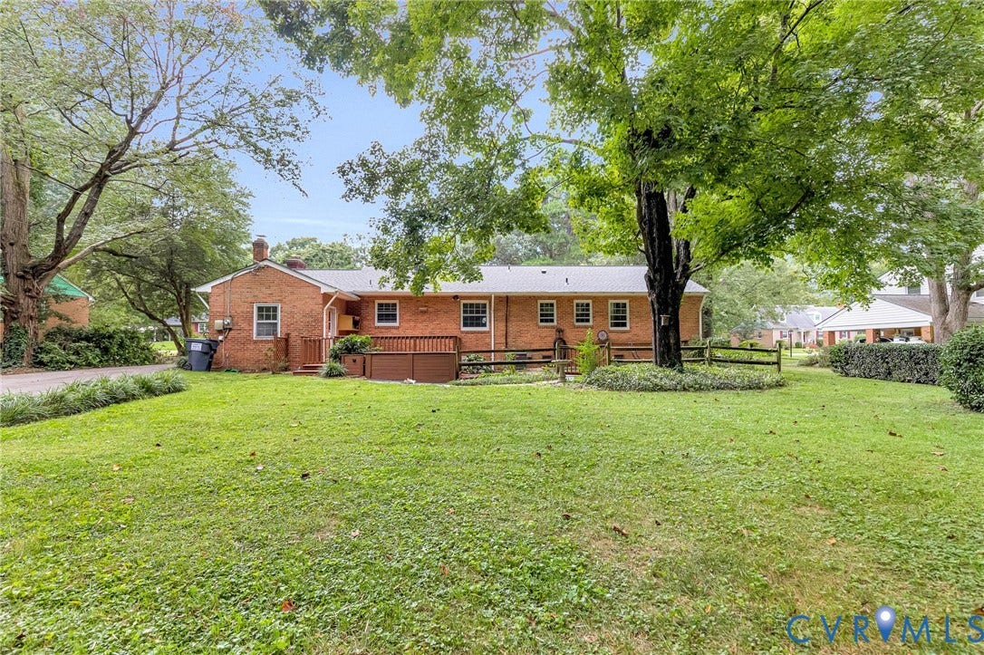 5215 Sprucewood Avenue, North Chesterfield, VA 23234 Expansive lawn area with mature trees, brick exterior, and a wood deck