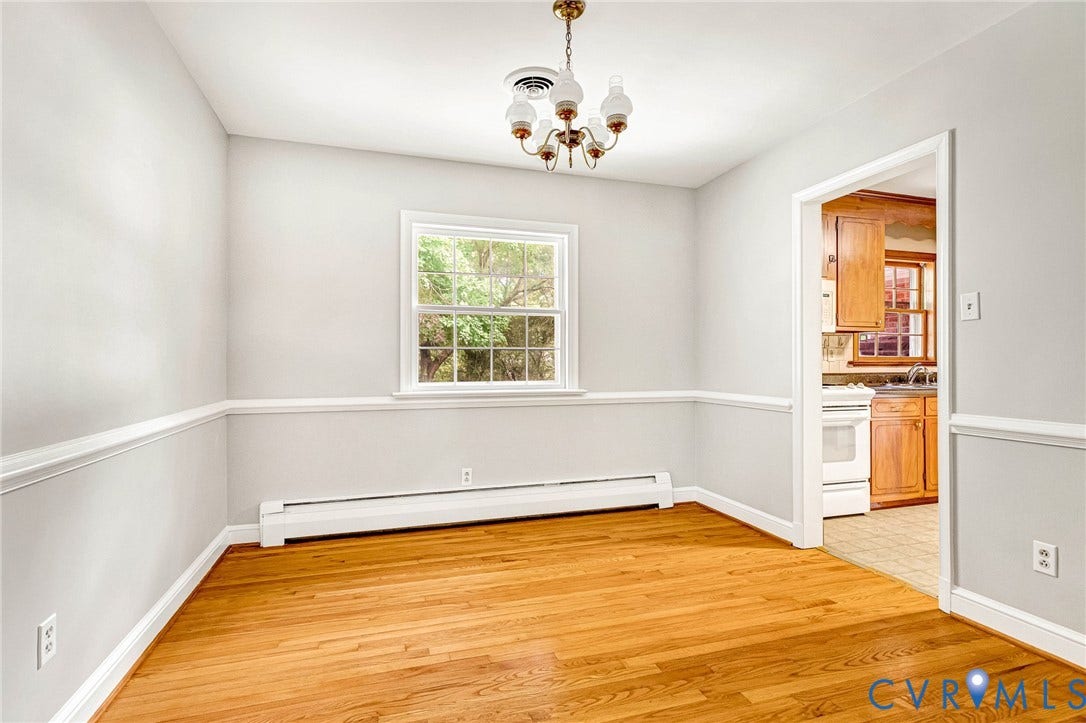 5215 Sprucewood Avenue, North Chesterfield, VA 23234 Hardwood flooring, chair rail molding, a window with exterior tree scenery, and a chandelier with glass shades