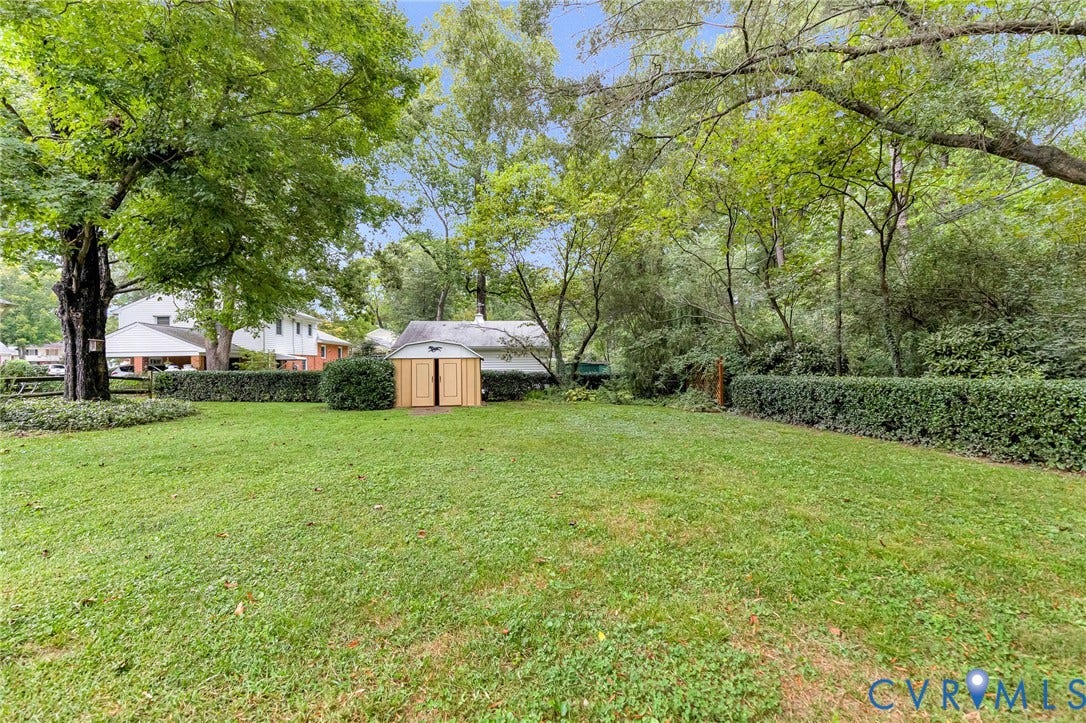 5215 Sprucewood Avenue, North Chesterfield, VA 23234 Expansive backyard featuring a manicured lawn, mature trees, and privacy hedging