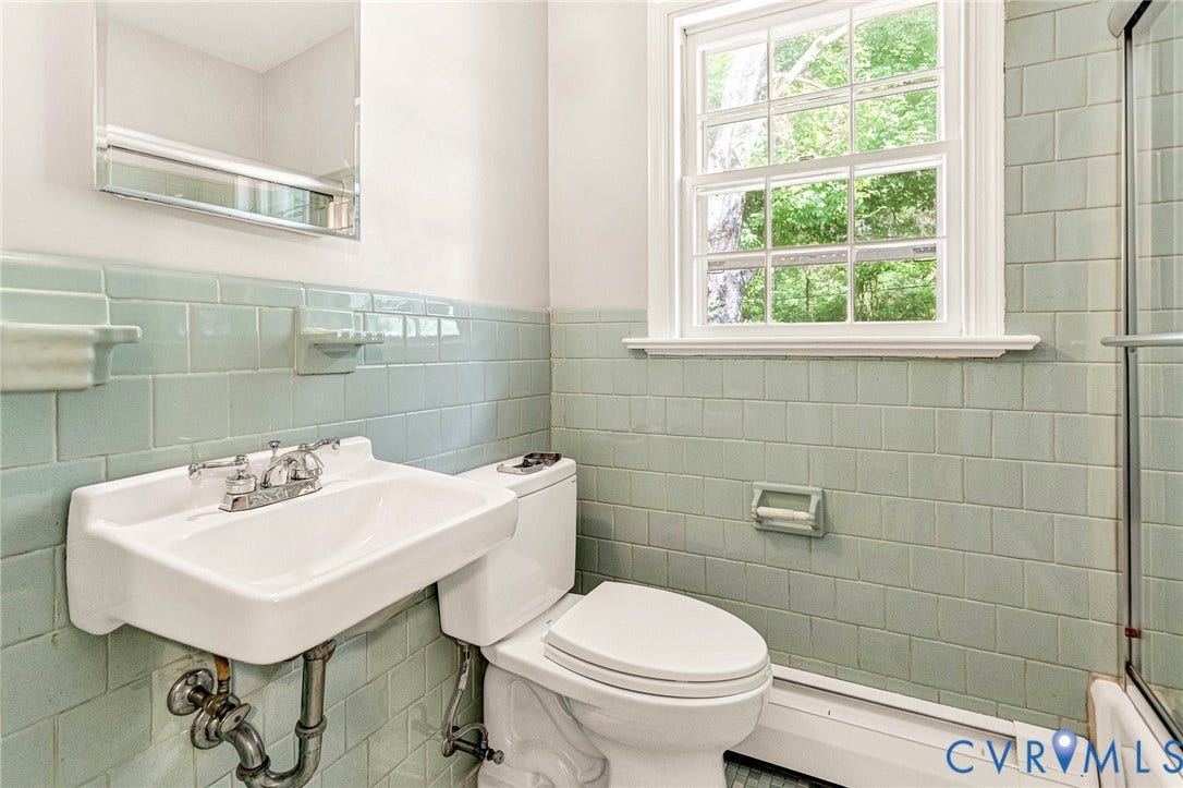 5215 Sprucewood Avenue, North Chesterfield, VA 23234 Wall-mounted vanity sink with chrome fixtures, complemented by subway tile wainscoting and a framed window