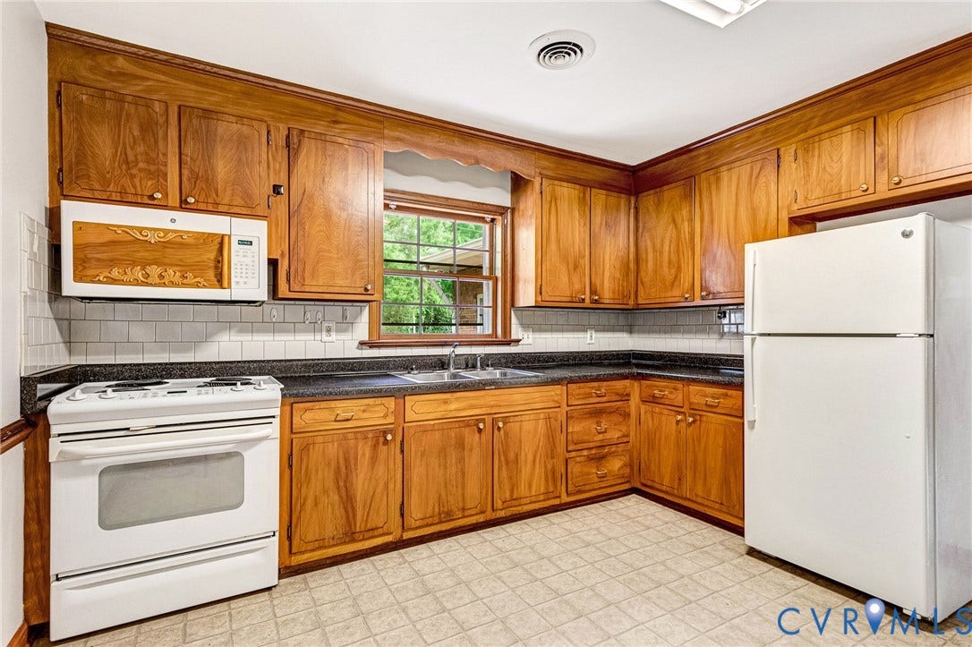 5215 Sprucewood Avenue, North Chesterfield, VA 23234 Wood cabinetry, dark countertops, white subway tile backsplash, and a window above the sink