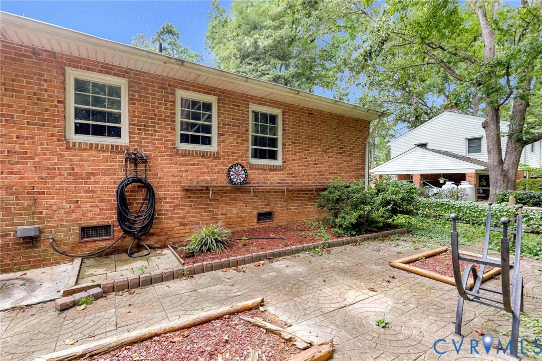 5215 Sprucewood Avenue, North Chesterfield, VA 23234 Brick exterior with multiple windows, concrete patio, and landscaping