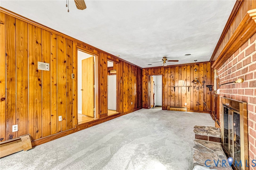 5215 Sprucewood Avenue, North Chesterfield, VA 23234 Brick fireplace with a stone hearth, wood-paneled walls, and light-colored carpet