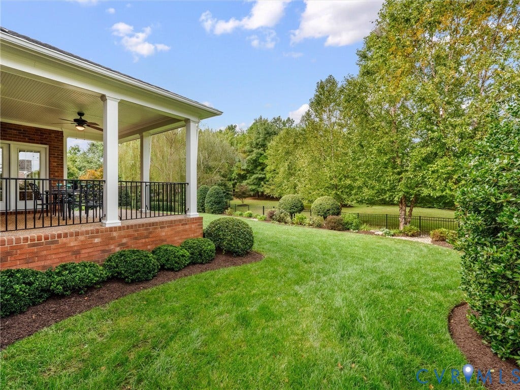 Expansive backyard featuring a manicured lawn, established perimeter fencing, and mature trees