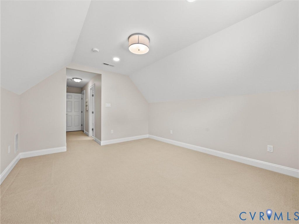 Sloped ceiling room featuring neutral-toned walls, recessed lighting, a flush mount ceiling fixture, and carpet flooring