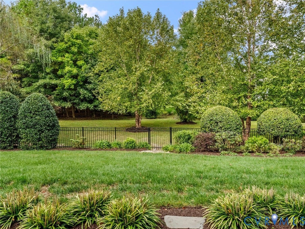 Expansive lawn bordered by mature trees and varied landscaping
