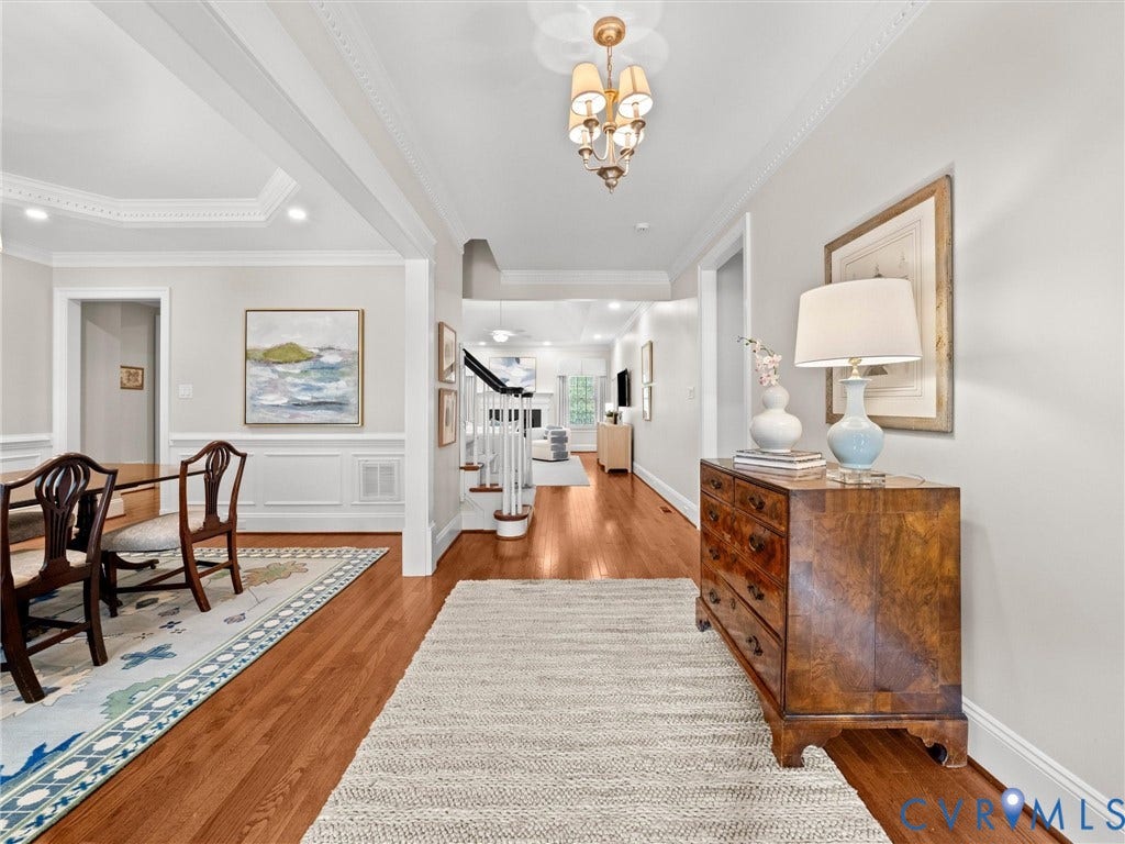 Hardwood flooring throughout, crown molding details, wainscoting, and recessed lighting