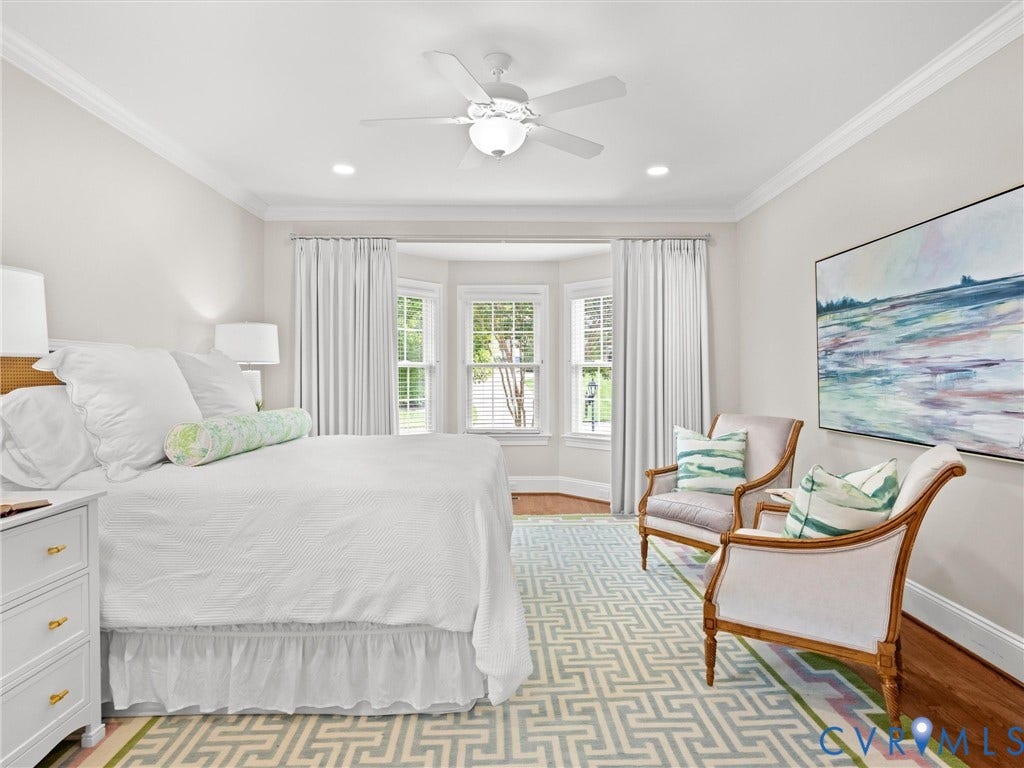 Bay window with plantation shutters, crown molding, recessed lighting, ceiling fan, and hardwood flooring