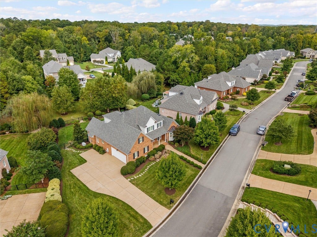 Brick exterior residence with a two-car garage, concrete driveway, and established landscaping