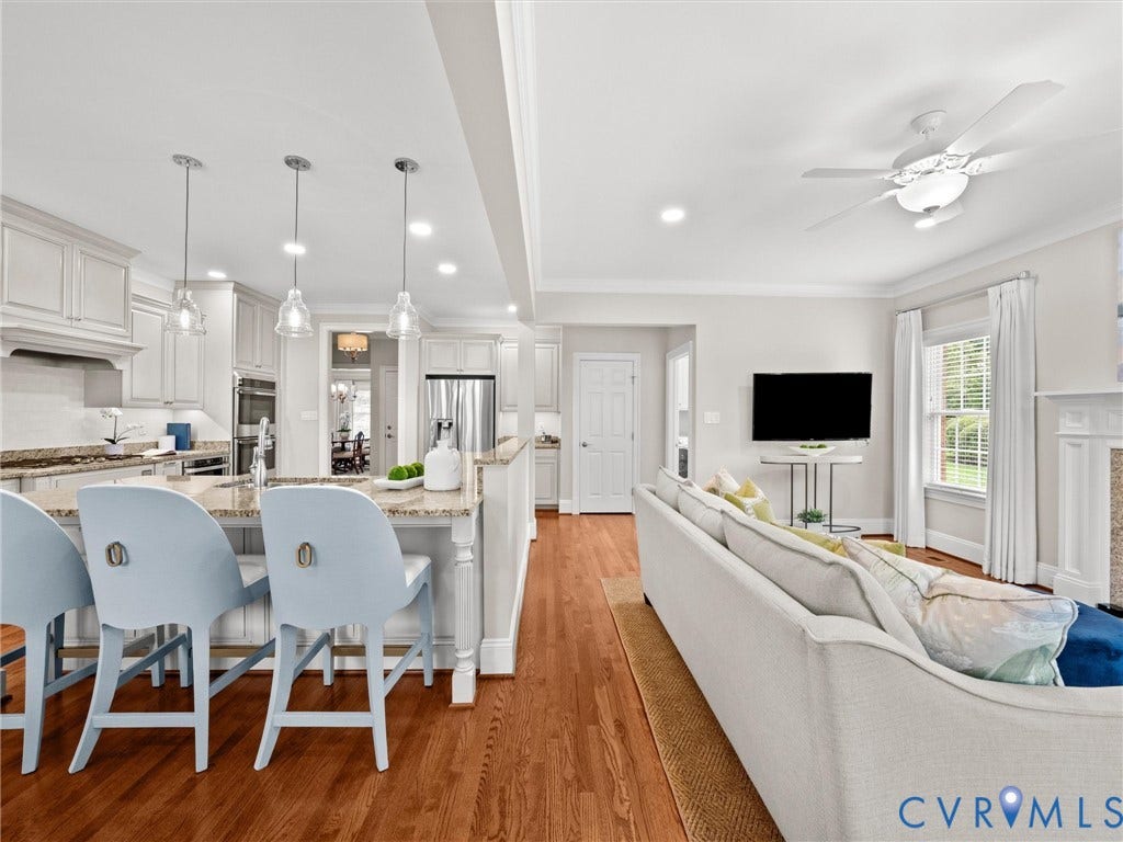 Hardwood flooring, kitchen island with granite countertop, stainless steel appliances, recessed lighting, and a ceiling fan