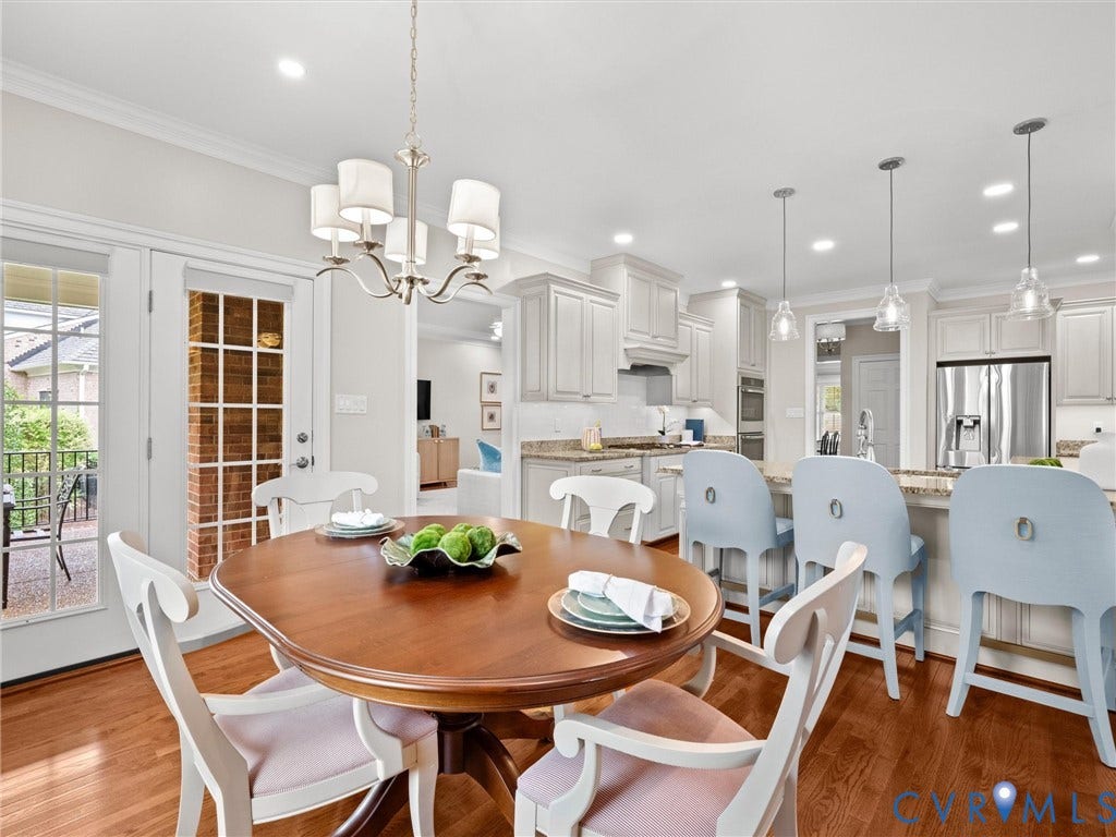 Hardwood flooring, crown molding, double French doors, recessed lighting, and a kitchen island with pendant lighting