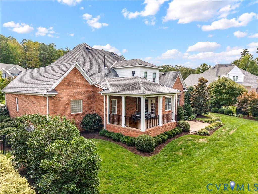 Brick exterior with a covered patio, white columns, and a stone patio