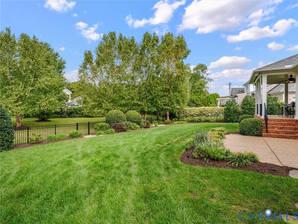 Expansive green lawn with mature trees and established landscaping