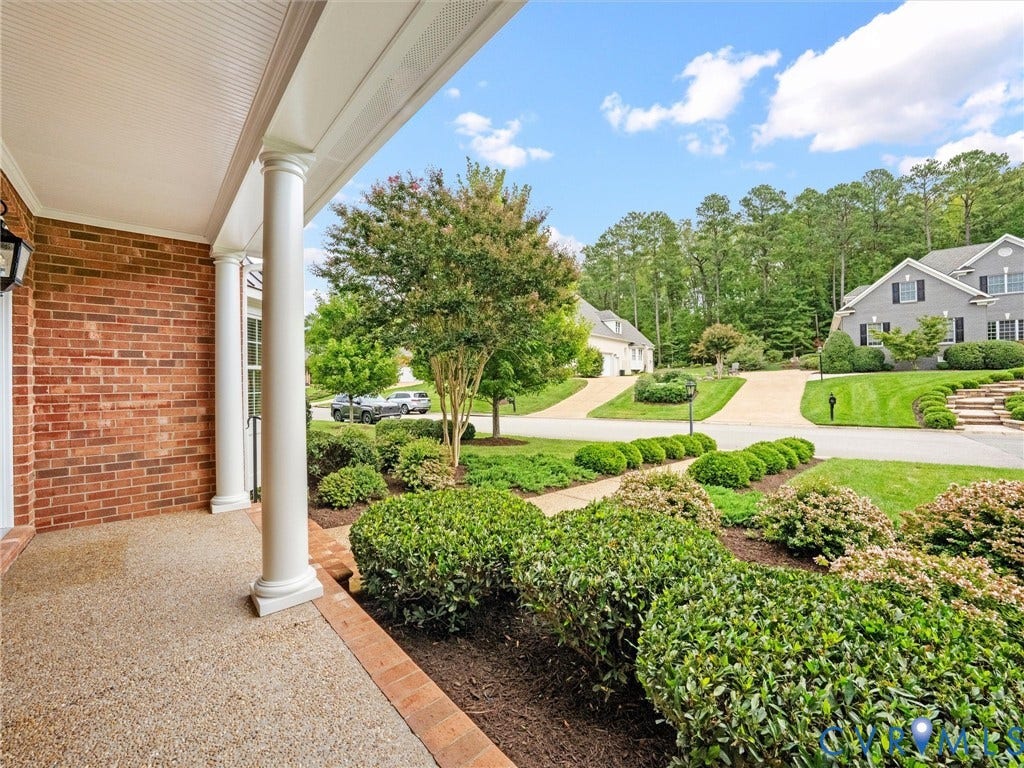Brick exterior with white columns and a textured concrete porch