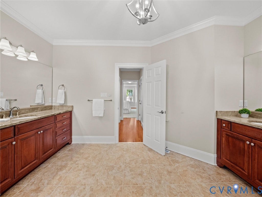 Dual vanity with integrated sinks, granite countertops, and wood cabinetry