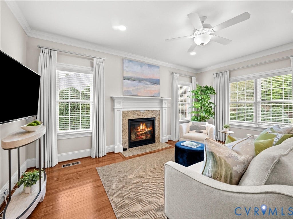 Hardwood flooring, tiled fireplace with a mantel, multiple windows, recessed lighting, and a ceiling fan