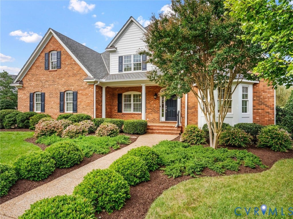 Brick exterior with white siding accents and dark shutters