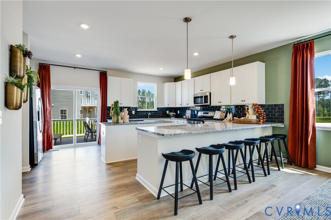 8708 Pullman Lane, Chesterfield, VA 23832 Kitchen featuring an island with stone countertop, white cabinetry, dark tile backsplash, stainless steel appliances, and wood-finish flooring