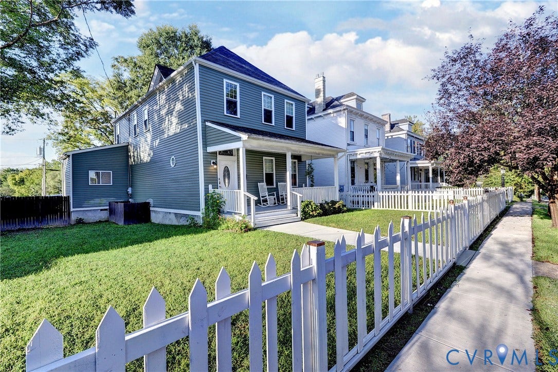 Two-story home with a covered front porch and a picket fence