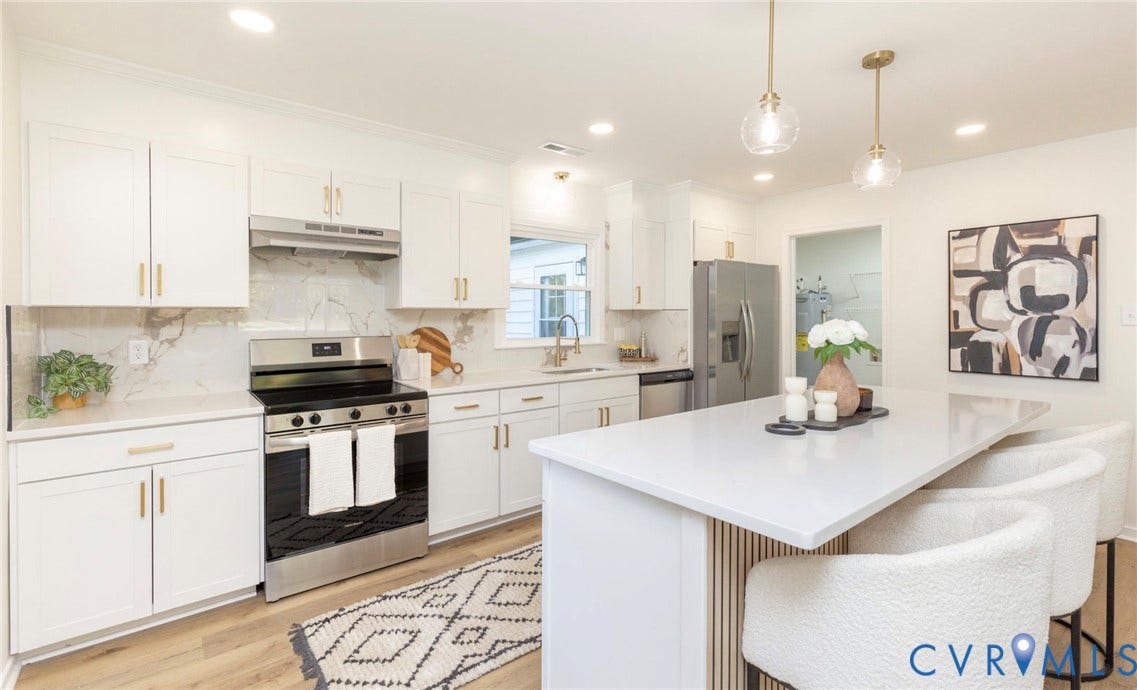 6015 Seaman Road, Westover, Richmond, VA 23225 White cabinetry with gold-tone hardware, stainless steel appliances, marble-effect backsplash, wood-finish flooring, and a central island with countertop seating
