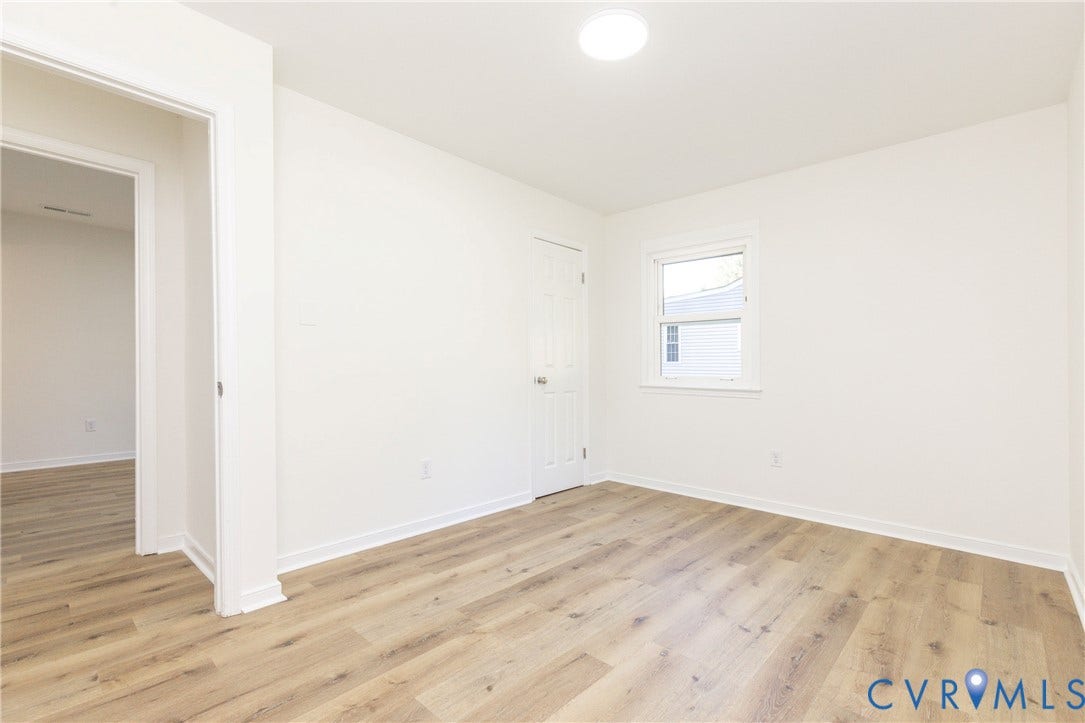 6015 Seaman Road, Westover, Richmond, VA 23225 Wood-finish flooring, white walls, white trim, recessed lighting, and a single window