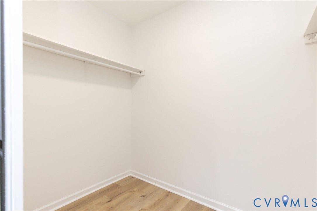 6015 Seaman Road, Westover, Richmond, VA 23225 White painted walls with wood-finish flooring and a single clothing rod