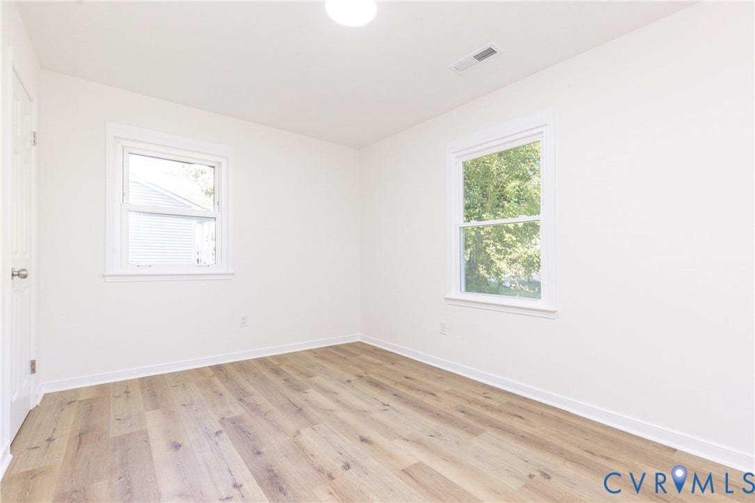 6015 Seaman Road, Westover, Richmond, VA 23225 Bright room featuring wood-finish flooring, white walls, and two single-hung windows with white trim