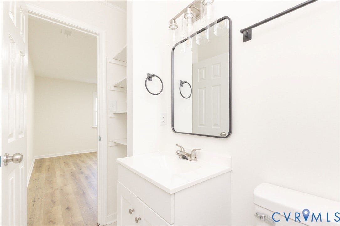 6015 Seaman Road, Westover, Richmond, VA 23225 Bathroom vanity with a white countertop and base, brushed nickel faucet, and a rectangular mirror