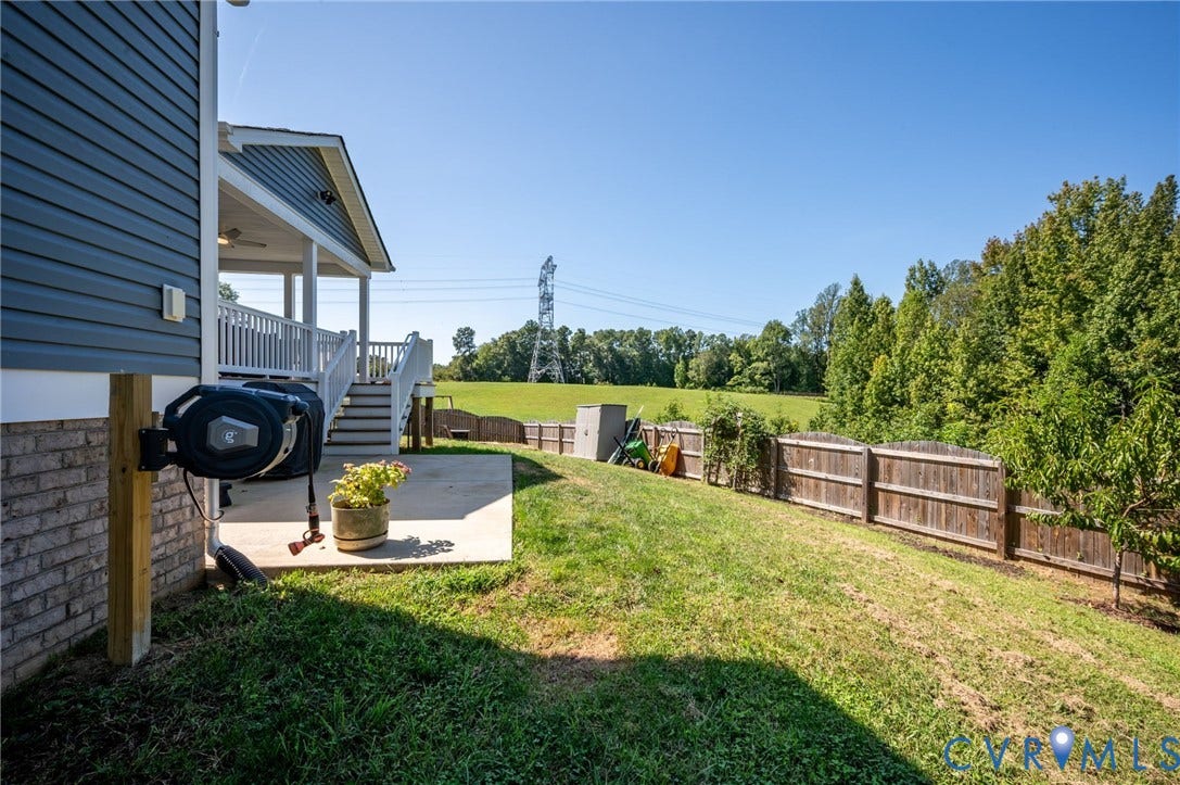 11804 Rydal Way, Cobbs Creek, Glen Allen, VA 23059 Lower level concrete patio, elevated covered porch, white railing, wood fence, and expansive grassy area